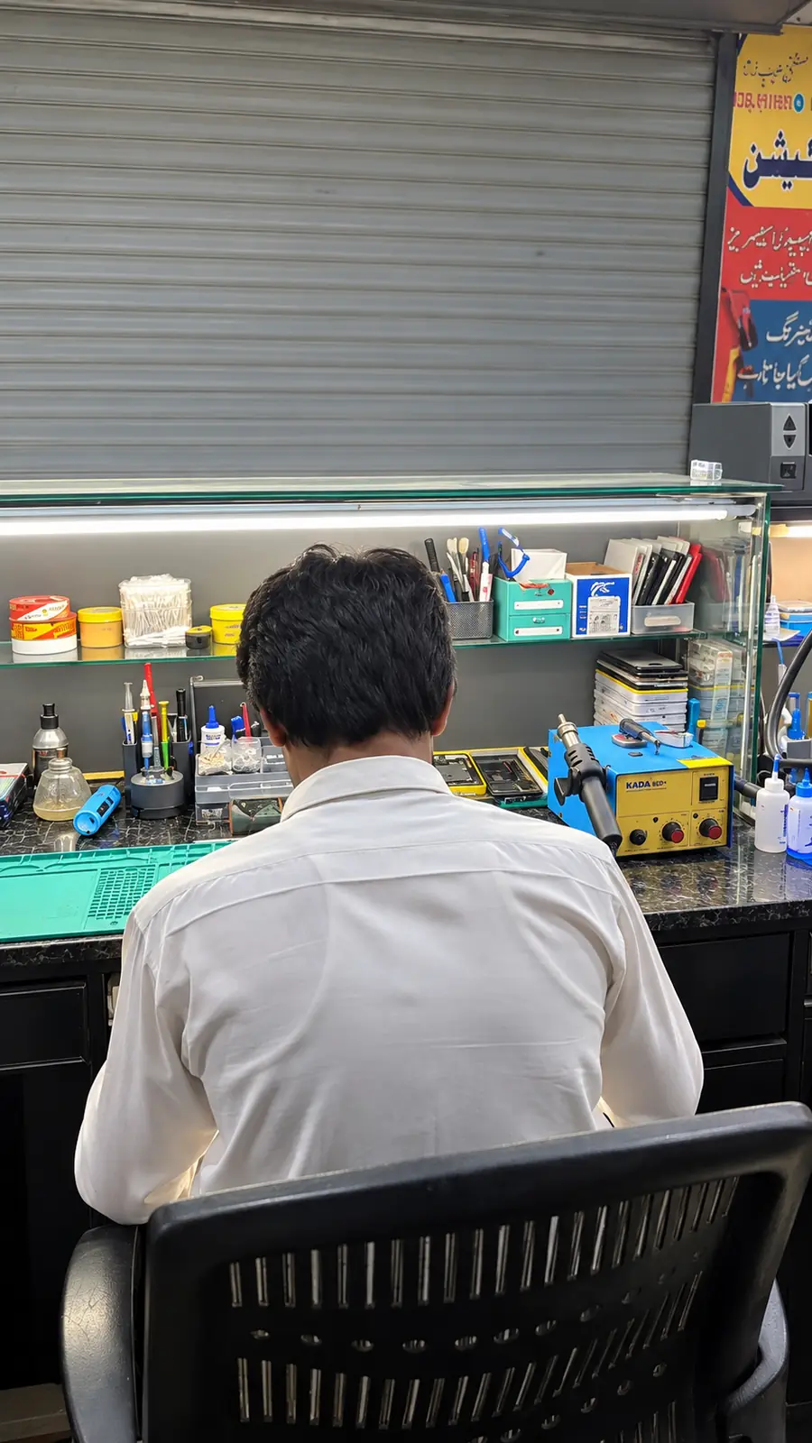 Technician working on a phone at the repair bench