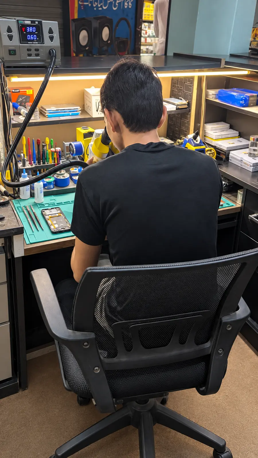 Technician repairing a phone at the bench